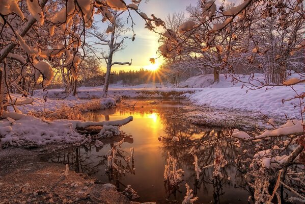 The frosty sun is reflected in the river