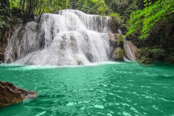 Azurblauer Fluss mit Wasserfall im Wald