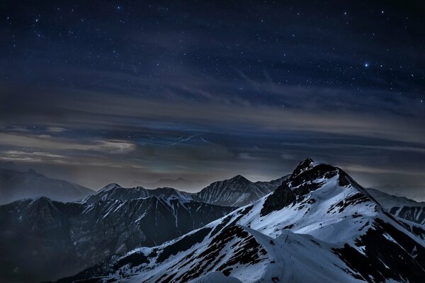 Snow-capped mountain peaks at night