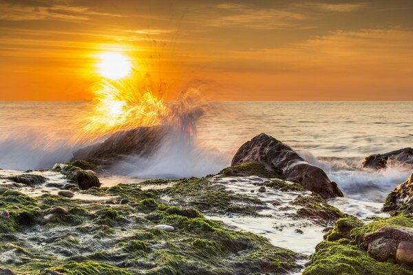 A wave is beating against big rocks