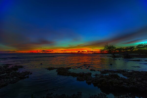 Puesta de sol ardiente con el mar