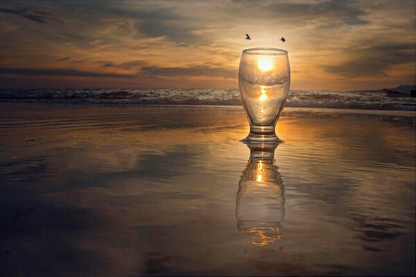 Reflet du soleil dans un verre sur fond de mer