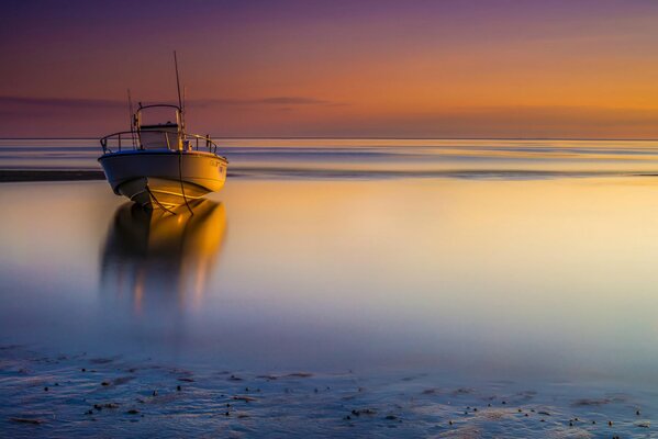 At the orange sunset in the sea boat