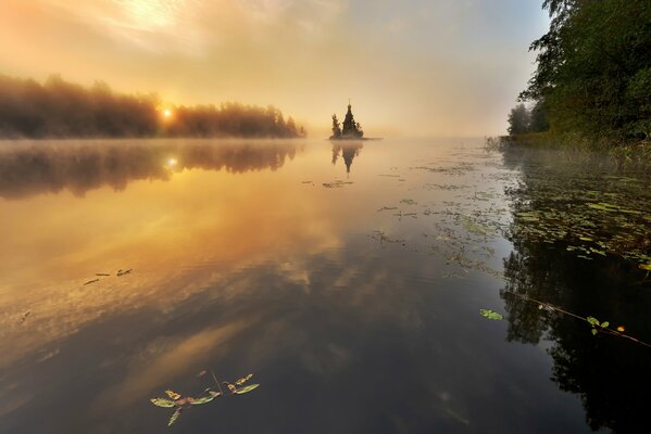 Autumn lake. The leaves float on the water. The temple is far away