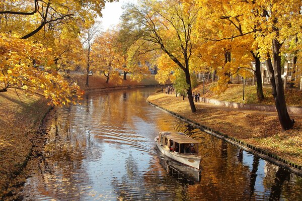 Naturaleza de otoño, barco en el canal