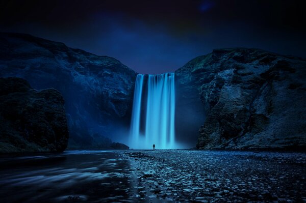 A gloomy waterfall seems to engulf a person