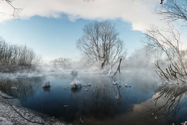 Winter landscape. Fog over the lake on a frosty morning