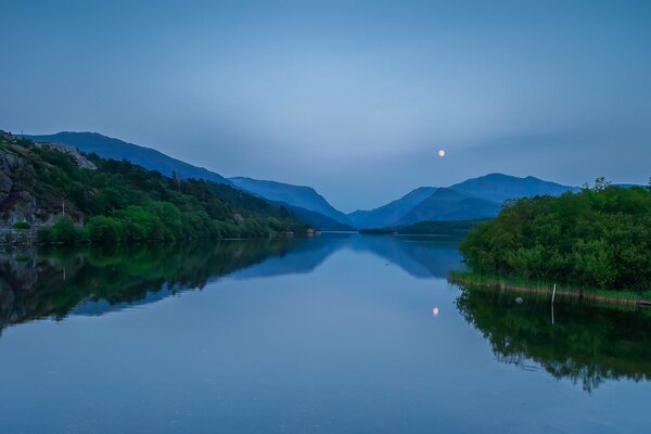 Noche tranquila con Luna llena en un lago en Gales