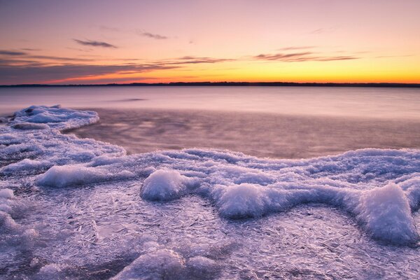 Icy lake in the rays of the setting sun