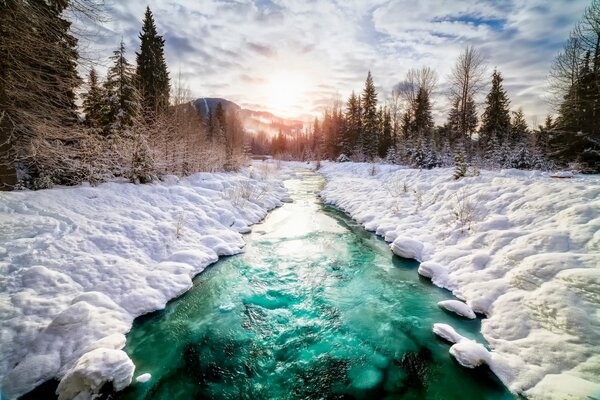 A river in Canada with snow under clouds