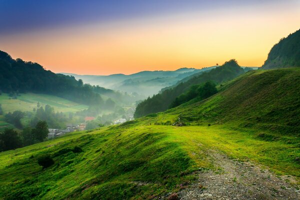 Grüne Lichtung in den Bergen vor dem Hintergrund des Sonnenuntergangs