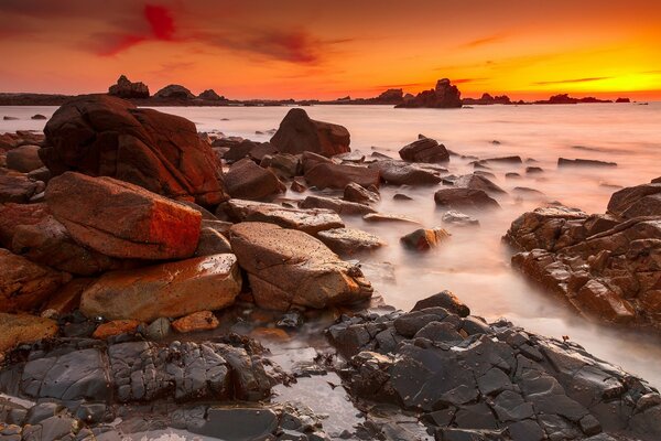 Sonnenuntergang am Meer mit Steinen