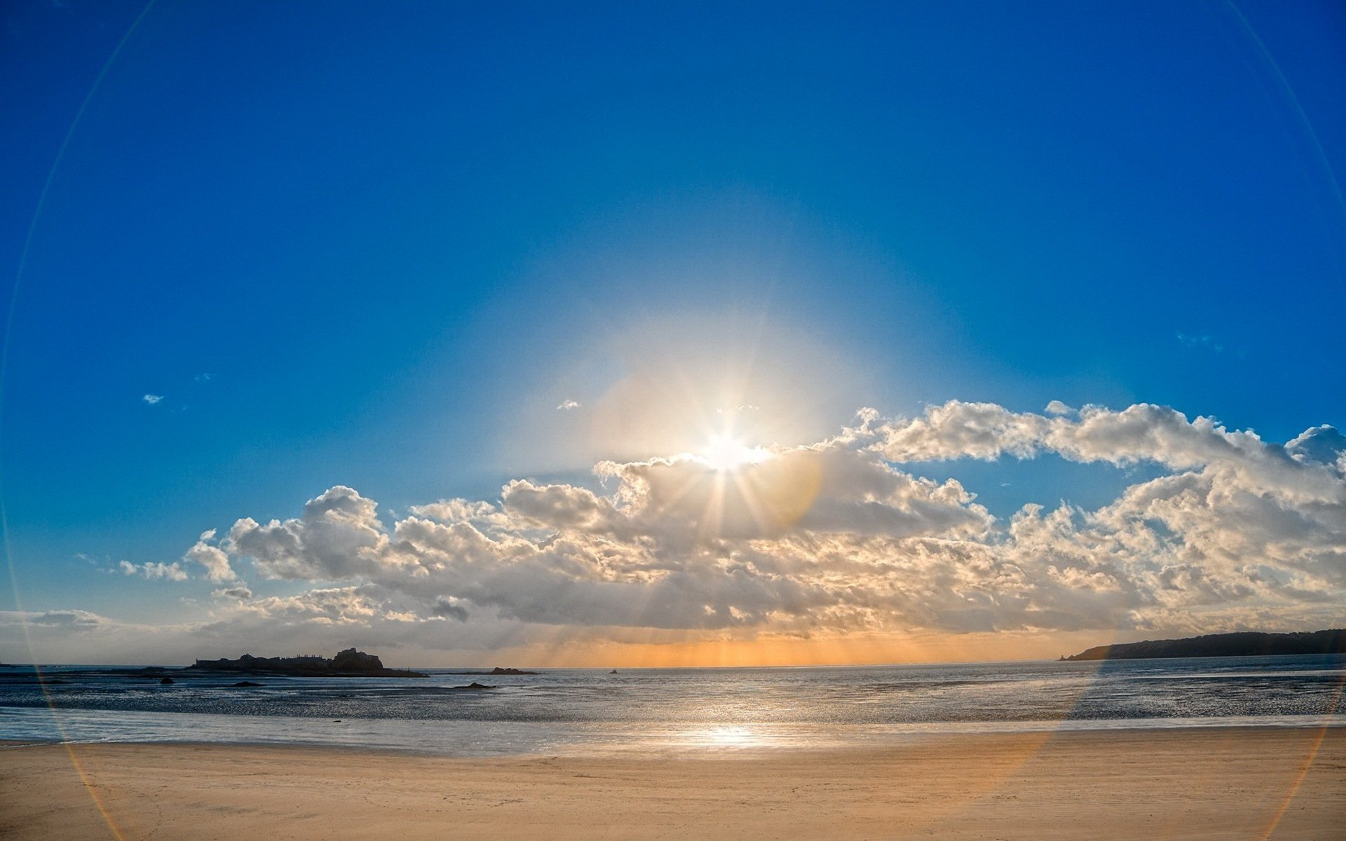 plage sable ciel nuages soleil éblouissement