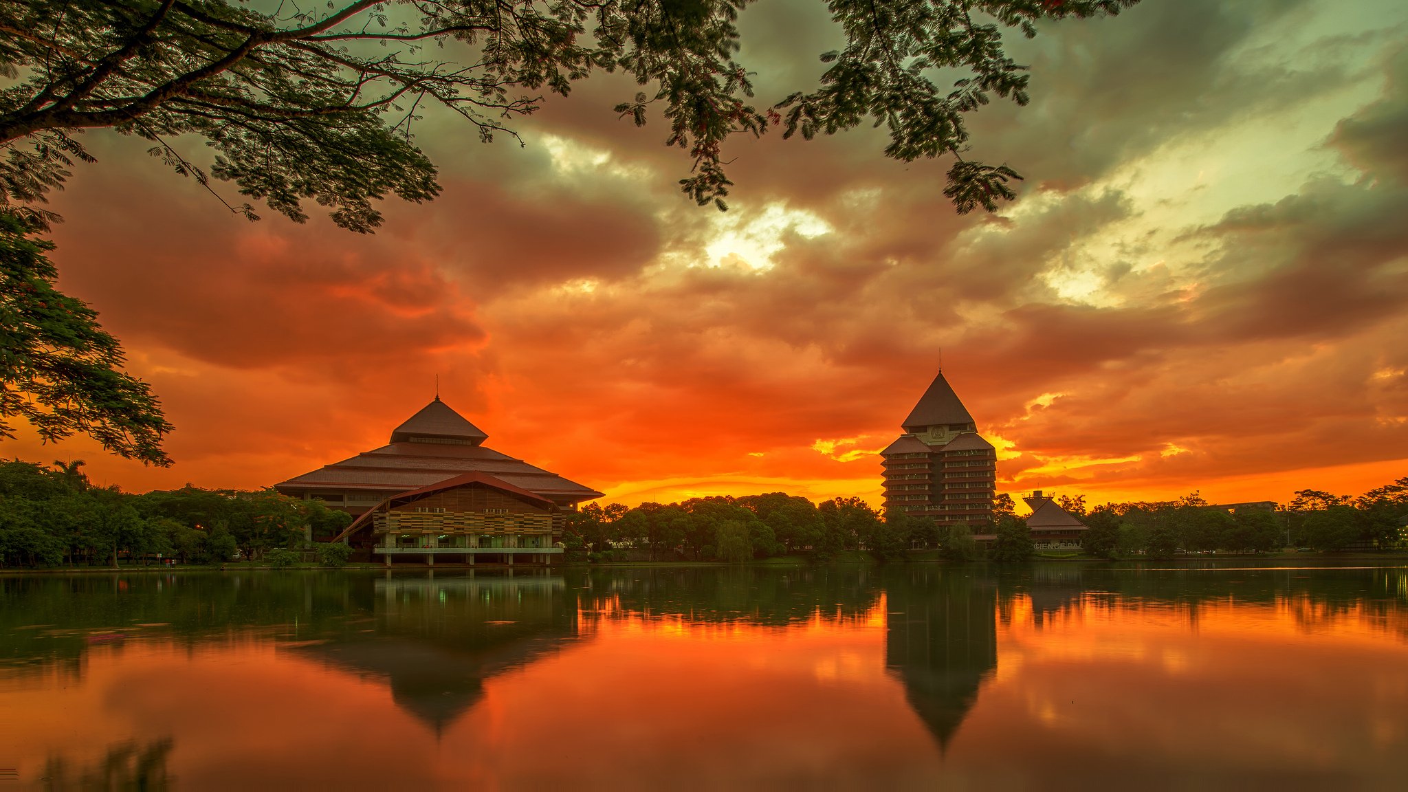 indonésie java île ville depok université bâtiments arbres rivière soirée coucher de soleil orange ciel nuages réflexion