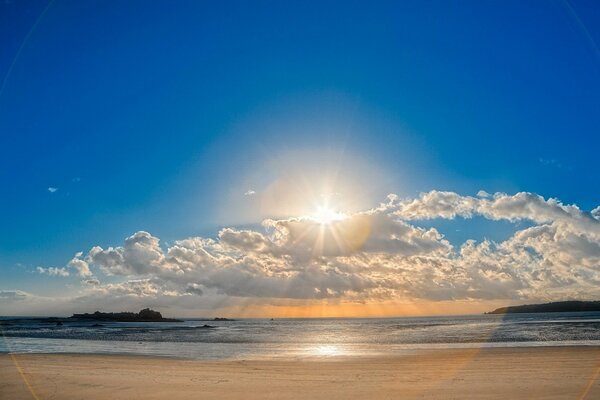 Playa junto al mar con nubes en el horizonte