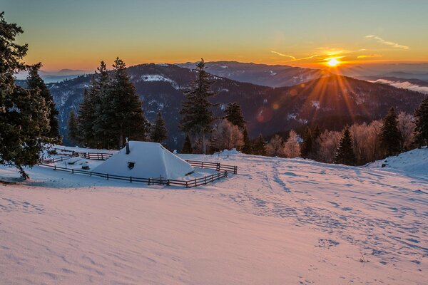 Mañana de nieve en las montañas. casa en las montañas