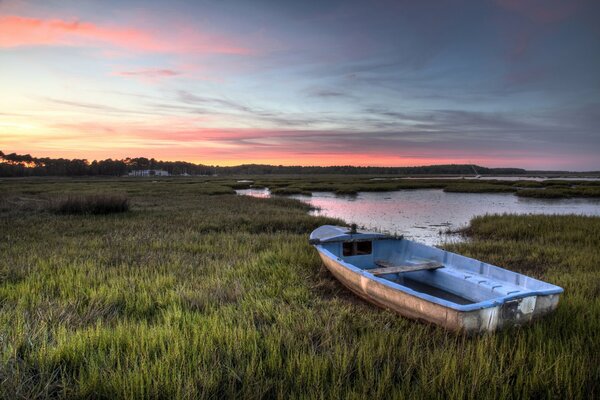 Bateau au bord du lac et coucher de soleil rose