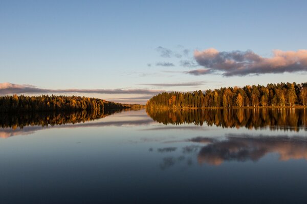 En el río ancho en el bosque se muestran las nubes