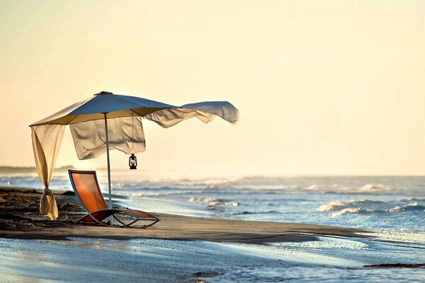 Sunbed on the seashore at sunset