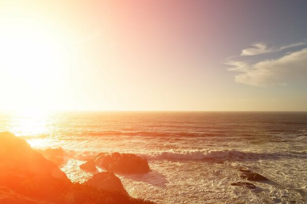 Las furiosas olas que rebotan en el sol golpean las rocas