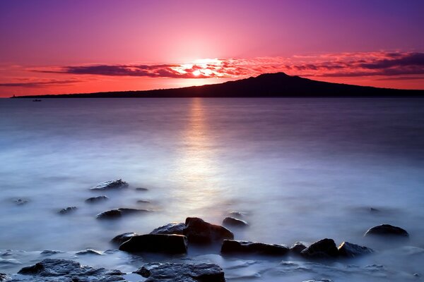 Sonnenaufgang in Neuseeland. Steine im Wasser