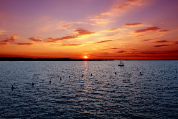 Yacht in mare su uno sfondo di tramonto rosso