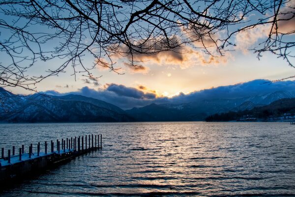 Lago sullo sfondo di montagna e tramonto