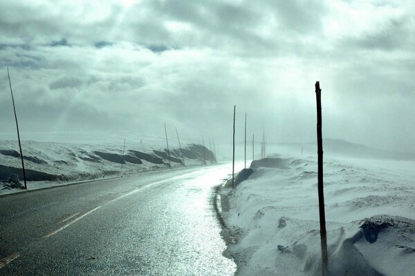 La lumière traverse les nuages. Route d hiver avec de la neige sur les bords de la route