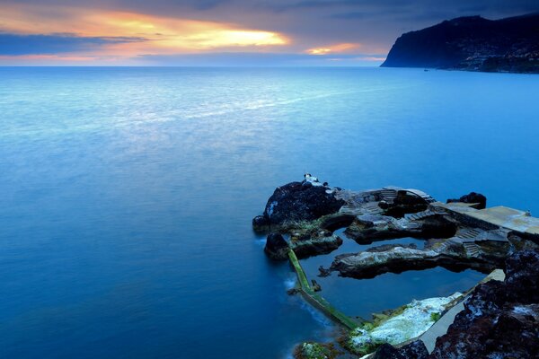 Island of rocks on the sea at sunset