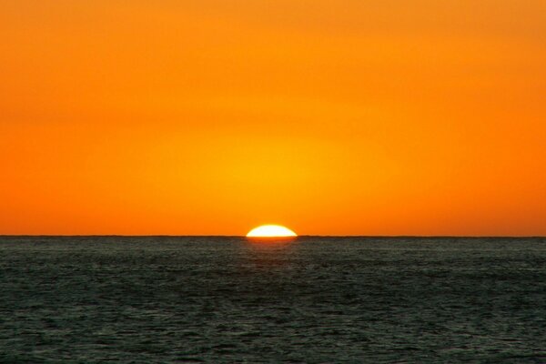 Puesta de sol naranja, la línea del horizonte del mar y el cielo