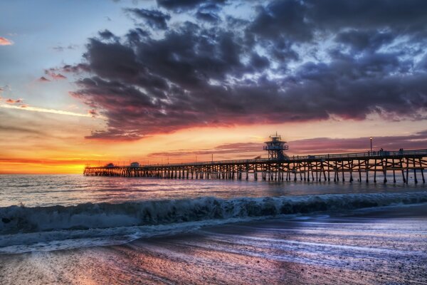 Puesta de sol en la costa y el muelle