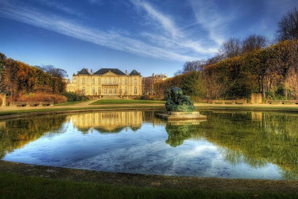 Ein schönes Herrenhaus spiegelt sich im Brunnen wider