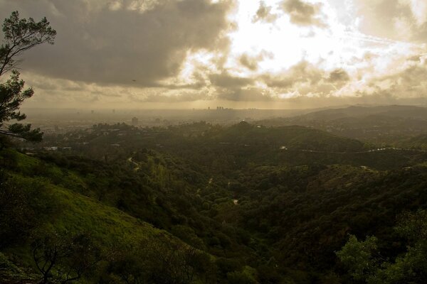 Green hills under the rays of the sun breaking through the clouds