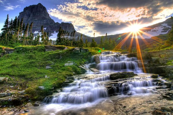 Ein Wasserfall, der in der Sonne von den Bergen abfließt