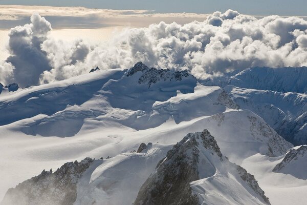 Picos nevados de montañas en las nubes