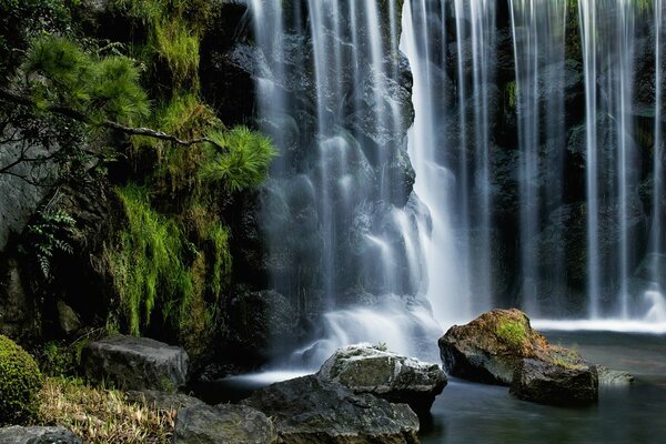 Hermosa cascada en el fondo de enormes piedras