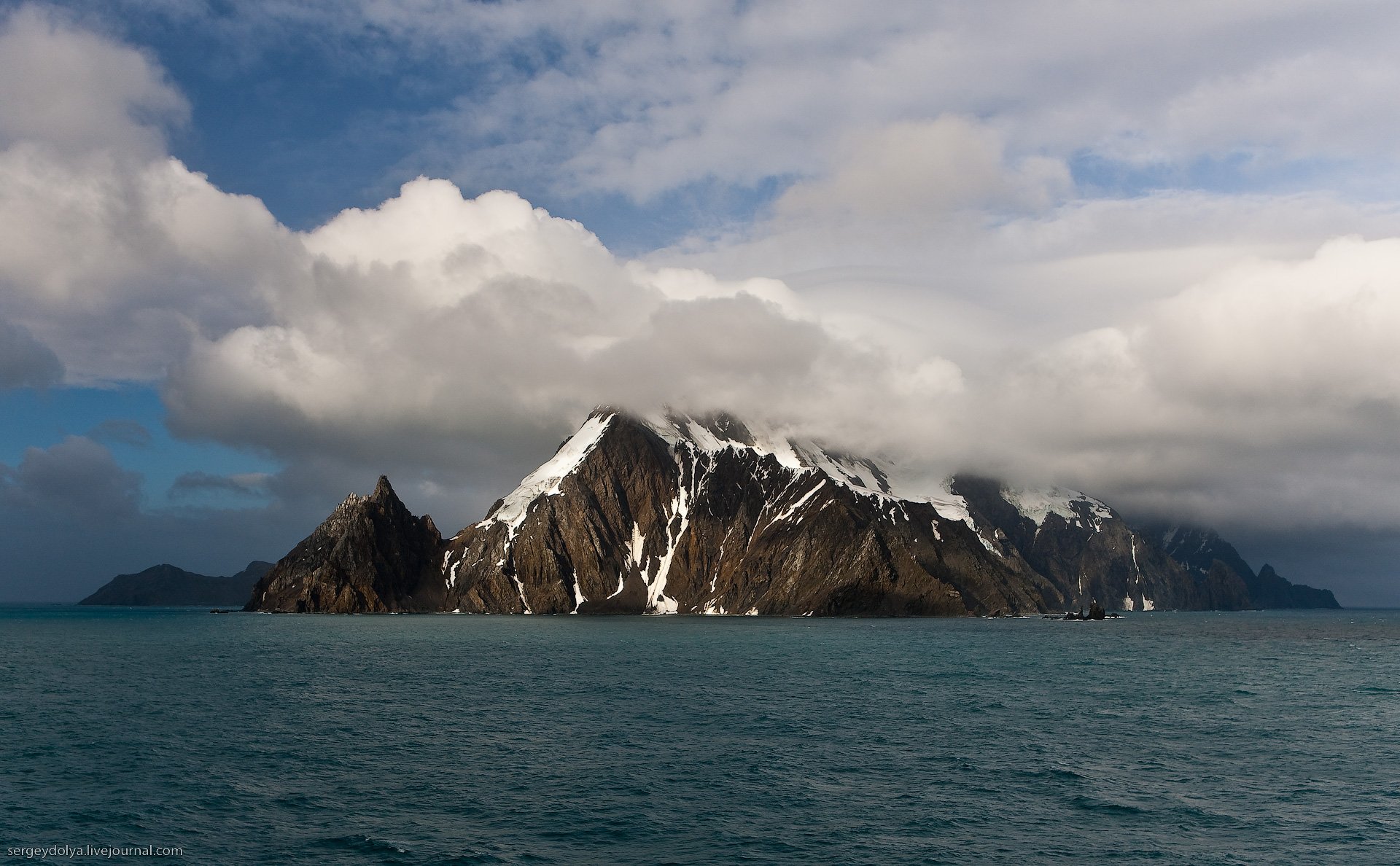 mountain rock clouds sea snow