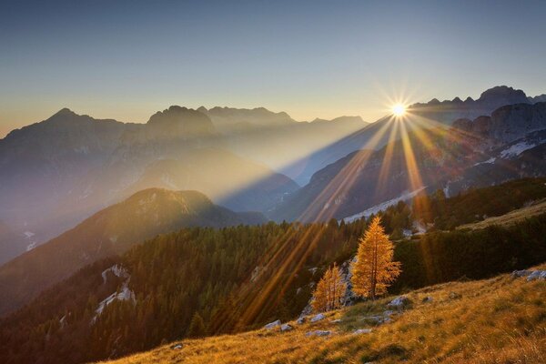 Beau coucher de soleil derrière les collines et les montagnes