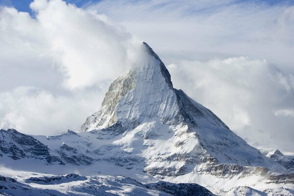 Schneebedeckte Bergspitze in den Wolken