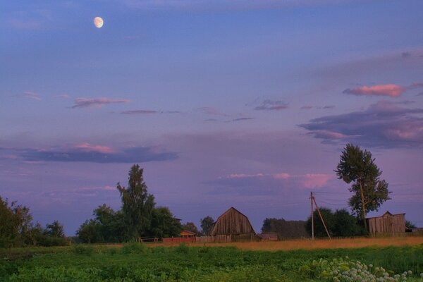 Photo in the village in summer with the moon