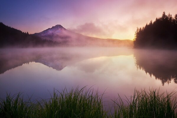 Nebbia sul lago. Montagne in lontananza