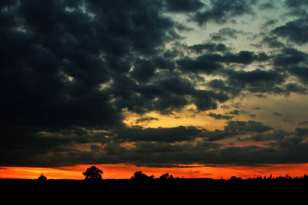 Orange sunset through dark clouds