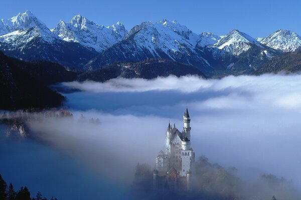 Misterioso castillo en las montañas temprano en la mañana en la niebla