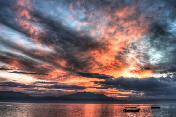 Ein blutiger Sonnenuntergang spiegelt sich im Meer wider