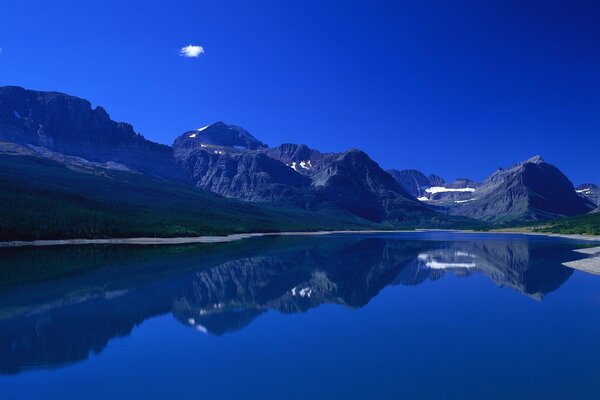 Mountains and grass are reflected in the water