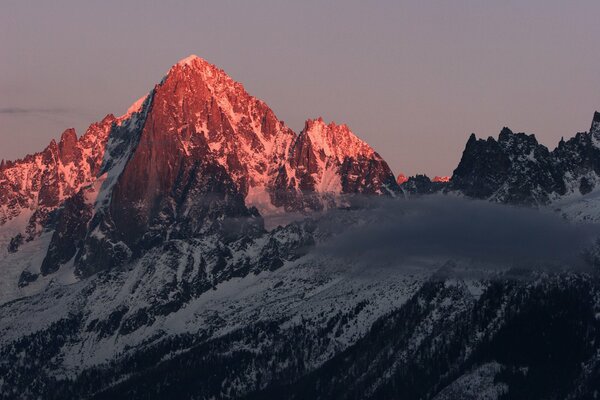 Alba nelle montagne innevate con le nuvole