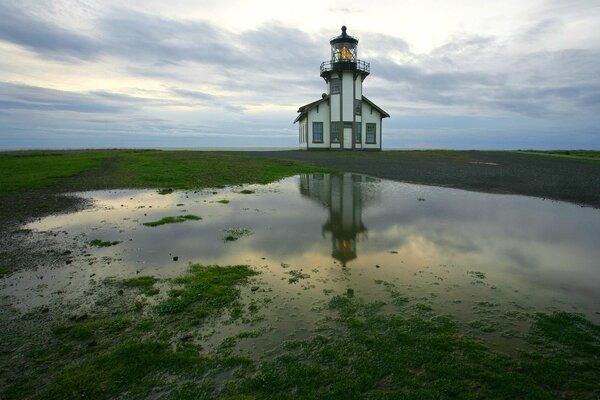 Reflection of a lighthouse in a puddle after rain