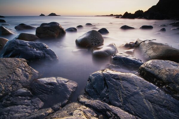 Orilla. playa de piedra. montañas junto al agua