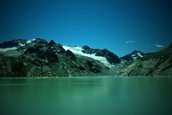 Lago verde cerca de las montañas