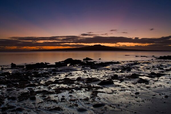 Rocky shore and lake at sunset